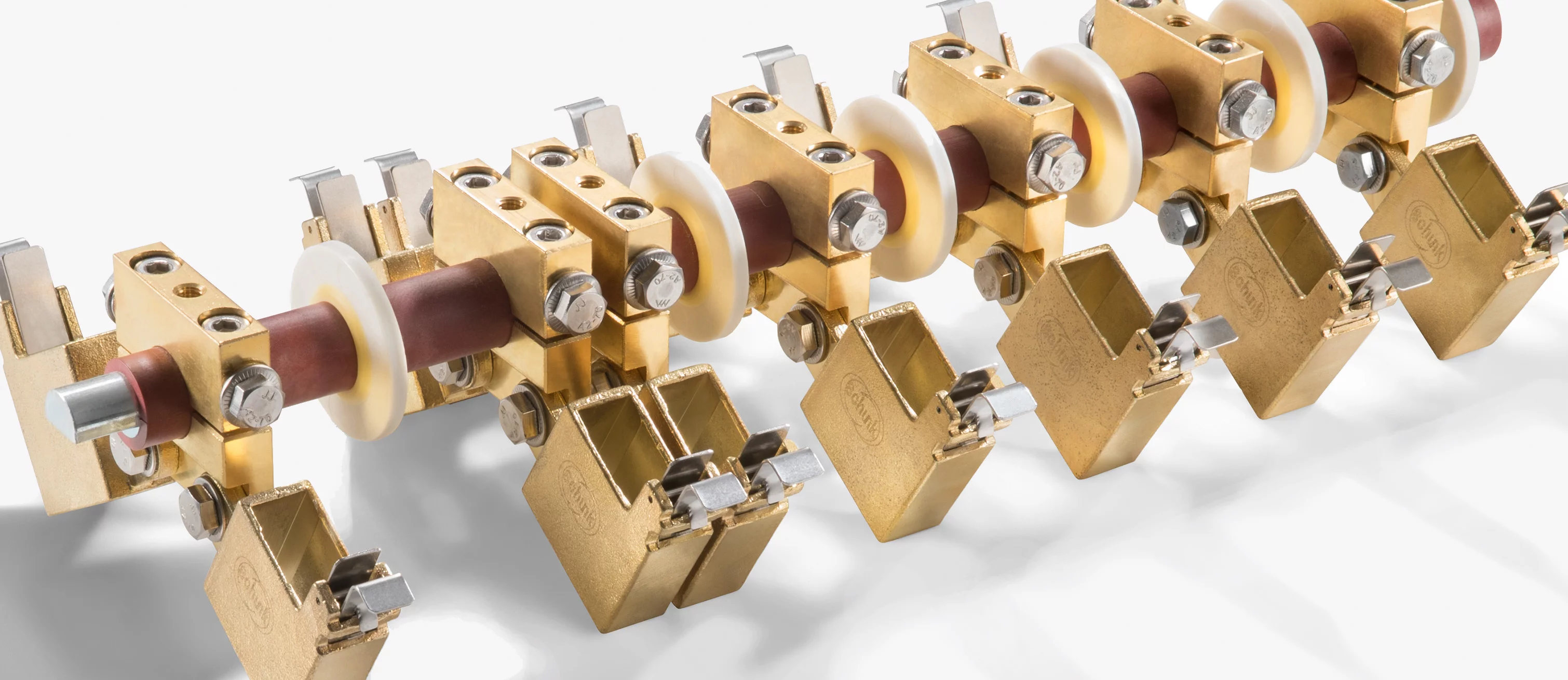  Close-up of an industrial current collector assembly with metal contact elements, insulators, and precision fastening.