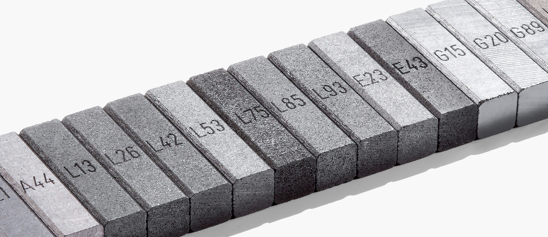  Row of labeled graphite samples with different material codes – representing the range of industrial carbon materials at Schunk.