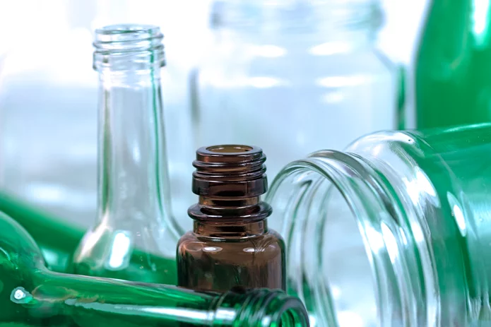  Verschiedenfarbige Glasflaschen und -behälter aus Braunglas, Grünglas und Klarglas – Nahaufnahme für Recycling oder Verpackung.