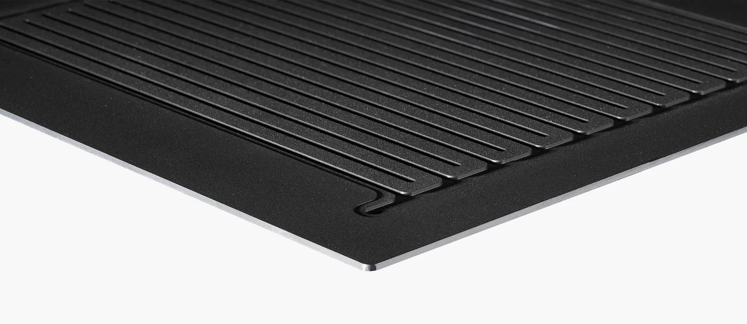  Close-up of a structured plate with fine flow channels, used as a flow field plate in fuel cells or electrolyzers.