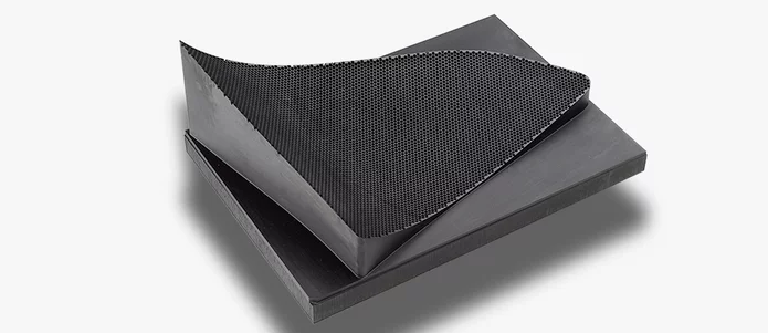  Werkstoffplatte mit feinmaschiger Wabenstruktur auf der Oberfläche, vermutlich aus Graphit oder faserverstärktem Verbundmaterial für industrielle Anwendungen.