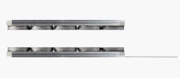  Zwei metallische Präzisionsbauteile mit gerillter Oberfläche zur Führung eines dünnen Band- oder Drahtmaterials.