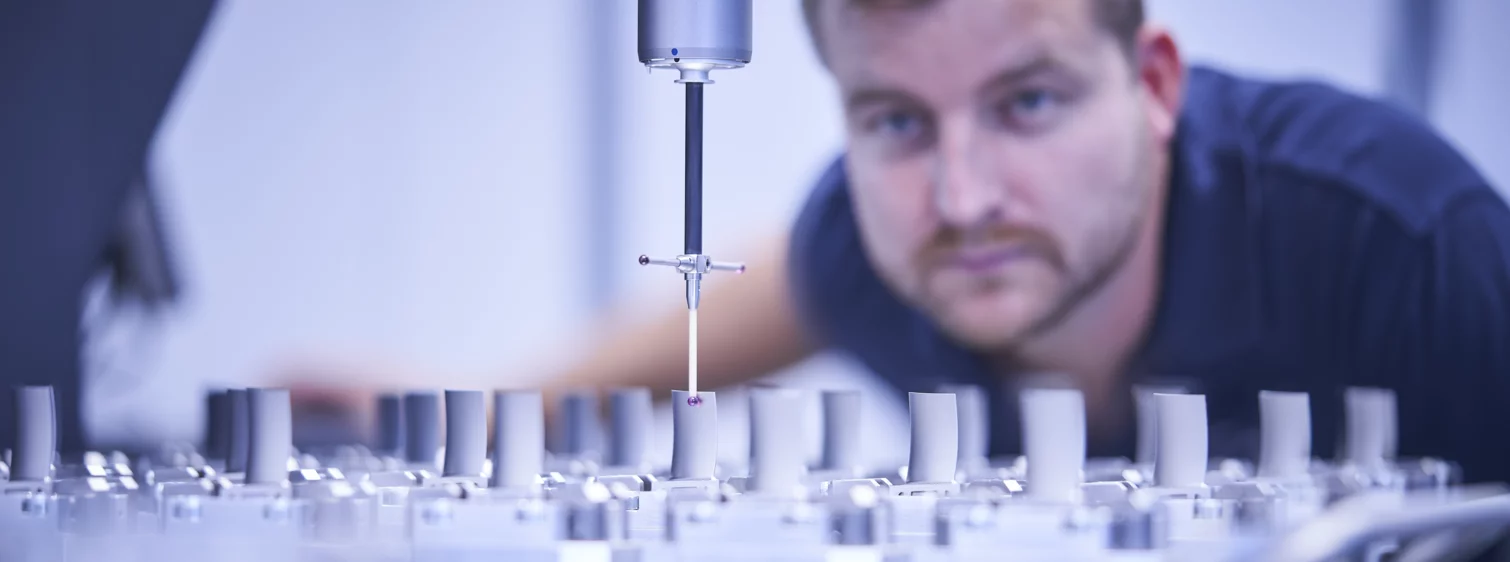  employee monitors a precise measurement of components with a coordinate measuring machine in a technical environment.