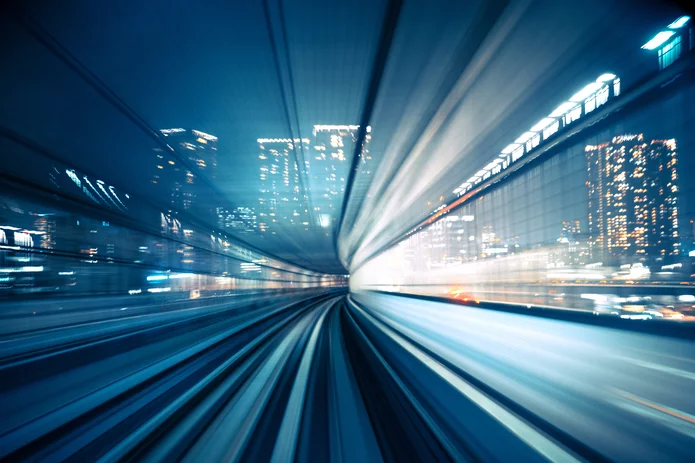  Dynamic view of a tunnel with city lights in the background, representing movement and speed in an urban environment.