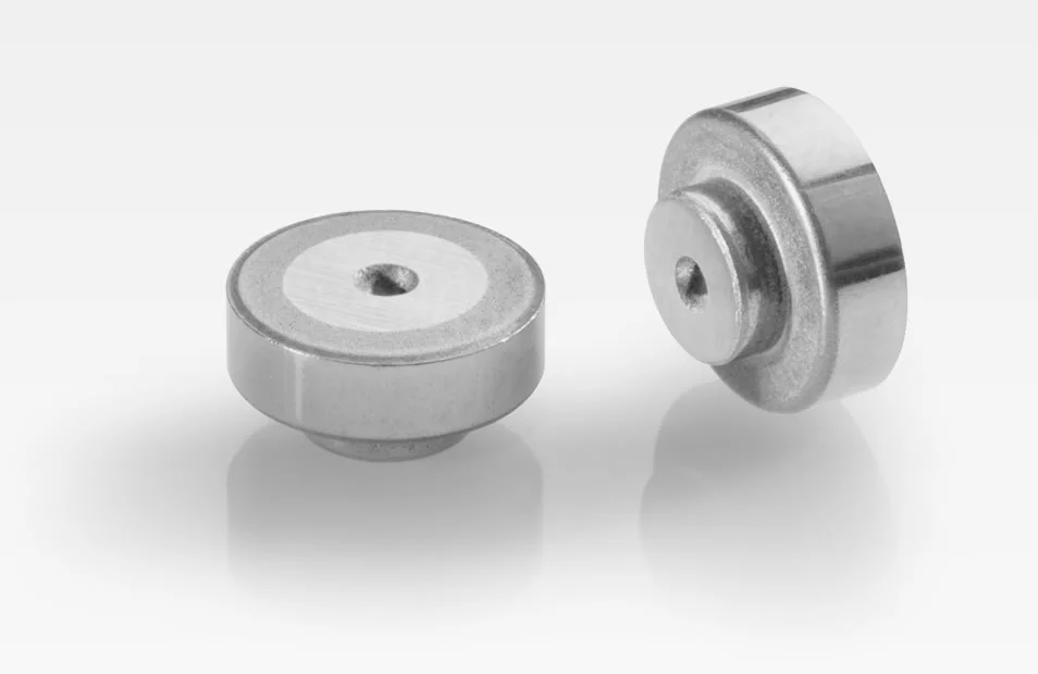 Zwei Walzkörper aus Metall für Turbolader mit flacher zylindrischer Form und zentraler Bohrung, vor weißem Hintergrund