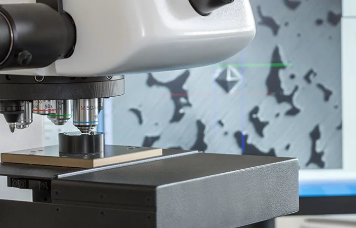 Testing procedure: Close-up of a microscope with a sample plate, microstructure displayed on a screen