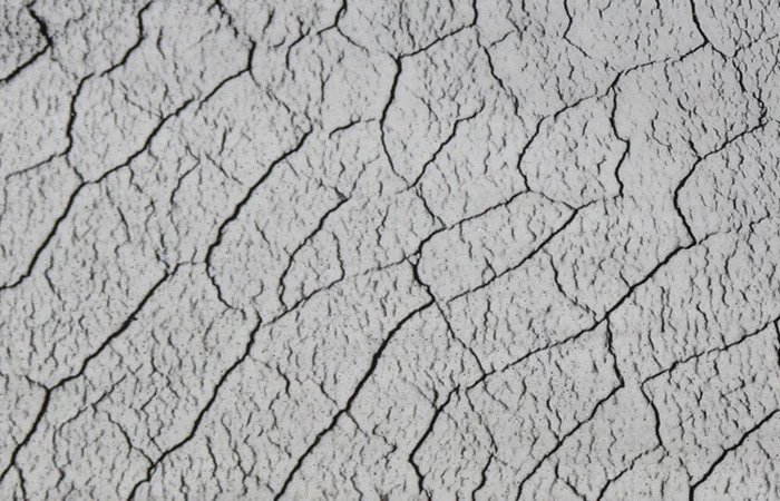  Oberfläche eines Materials mit feinen Rissen, Darstellung eines Prüfverfahrens zur Untersuchung von Strukturen