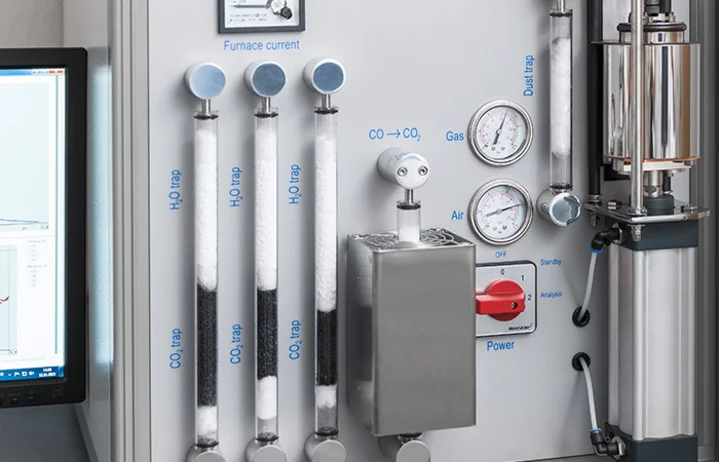 Close-up of a testing device with scales, gauges, and tubes for material analysis and quality control