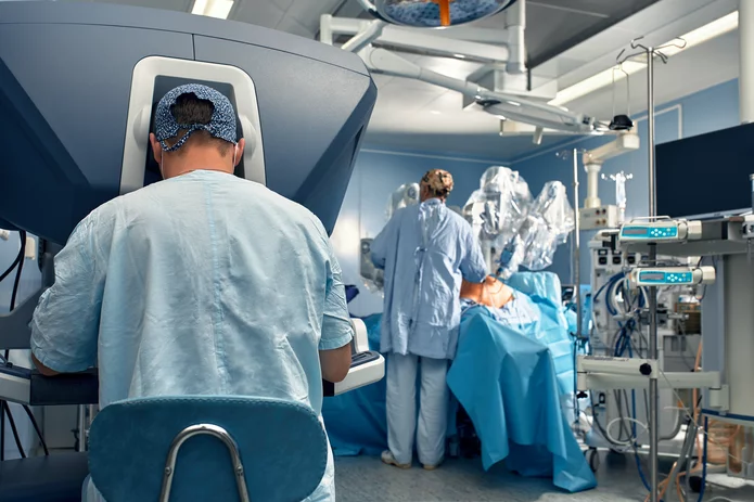  Chirurgisches Team bei einer robotergestützten Operation in einem modernen Operationssaal