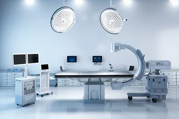  Moderner Operationssaal mit OP-Tisch, medizinischen Monitoren und bildgebendem C-Bogen-System