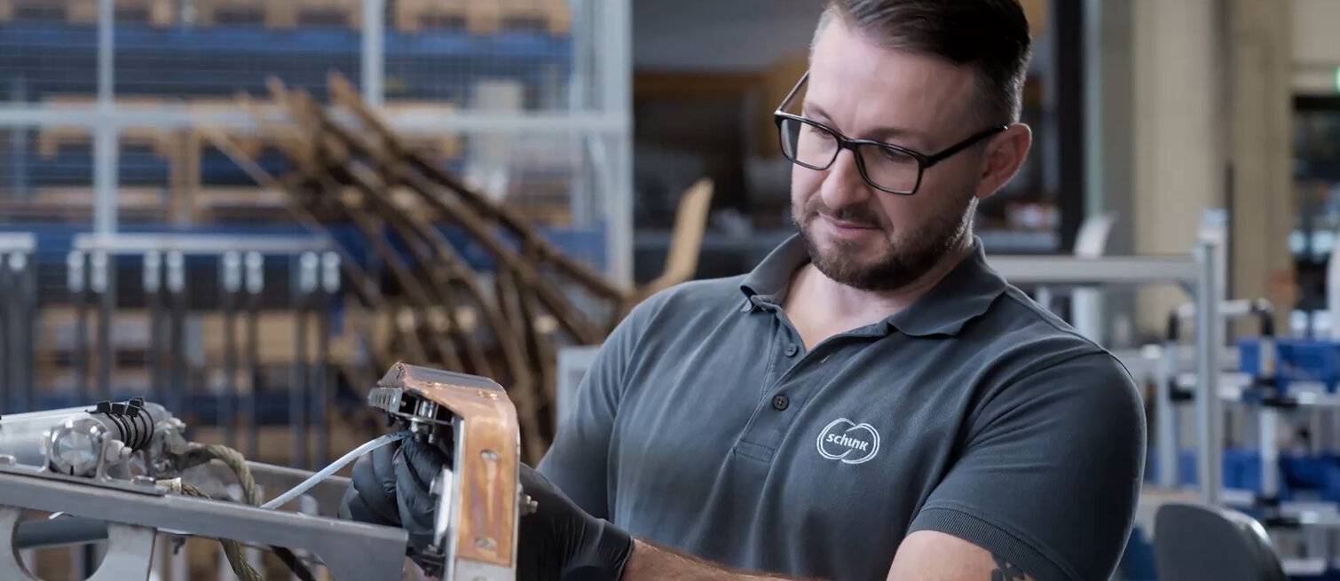 Service employee from Schunk Transit Systems inspecting a contact strip