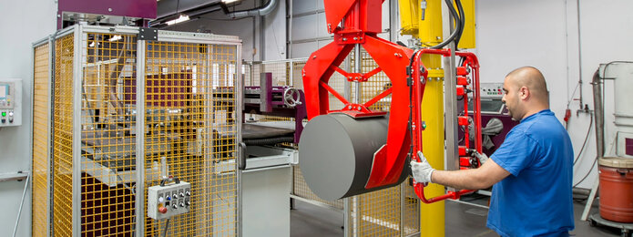 employee controlling a large machine lifting a barrel