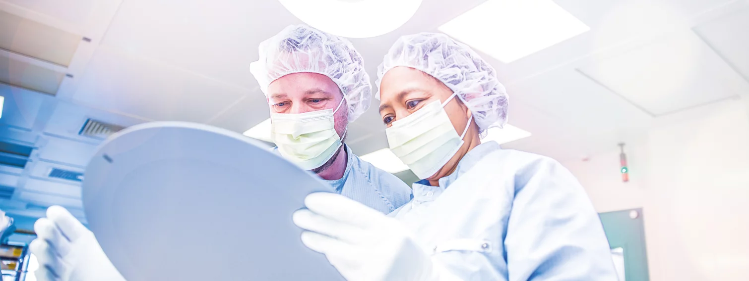 two employees in safety clothing and smocks at work