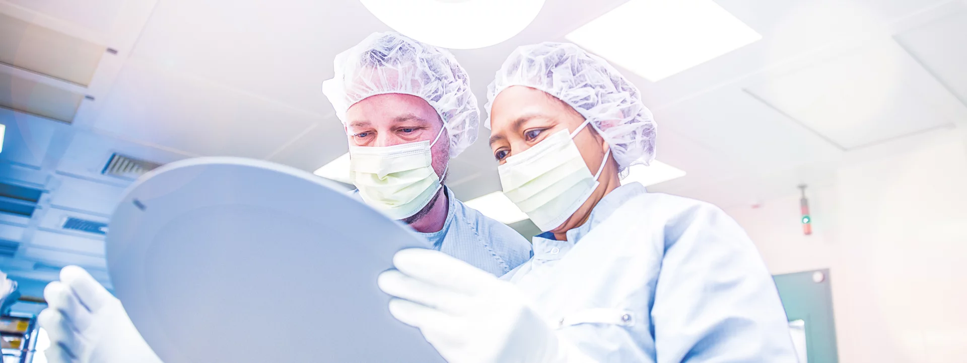 two employees in safety clothing and smocks at work
