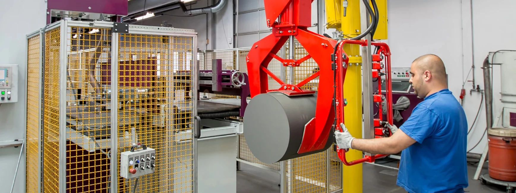 employee controlling a large machine lifting a barrel