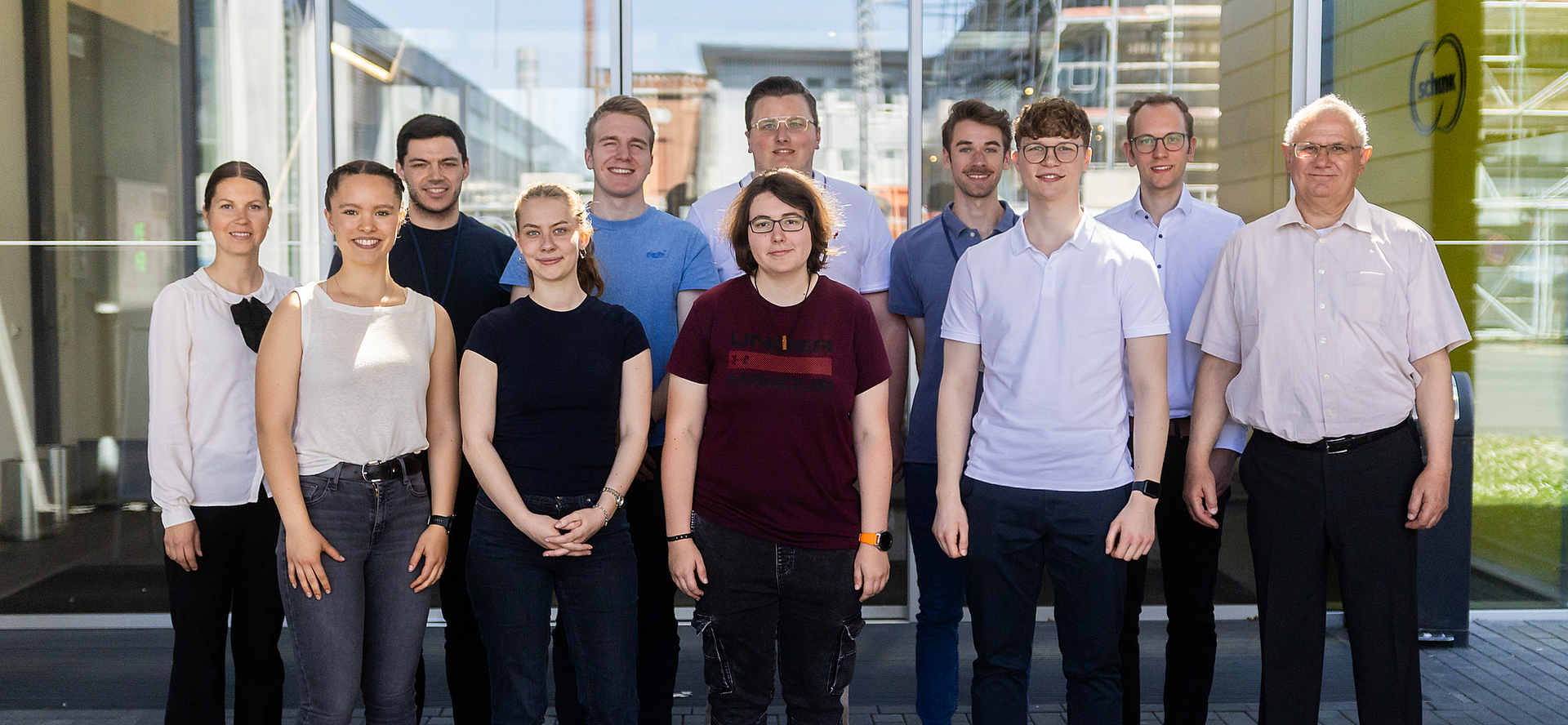 Gruppenfoto von Stipendiatinnen und Stipendiaten des Deutschlandstipendiums mit Betreuenden der Ludwig-Schunk-Stiftung vor dem Schunk-Gebäude.