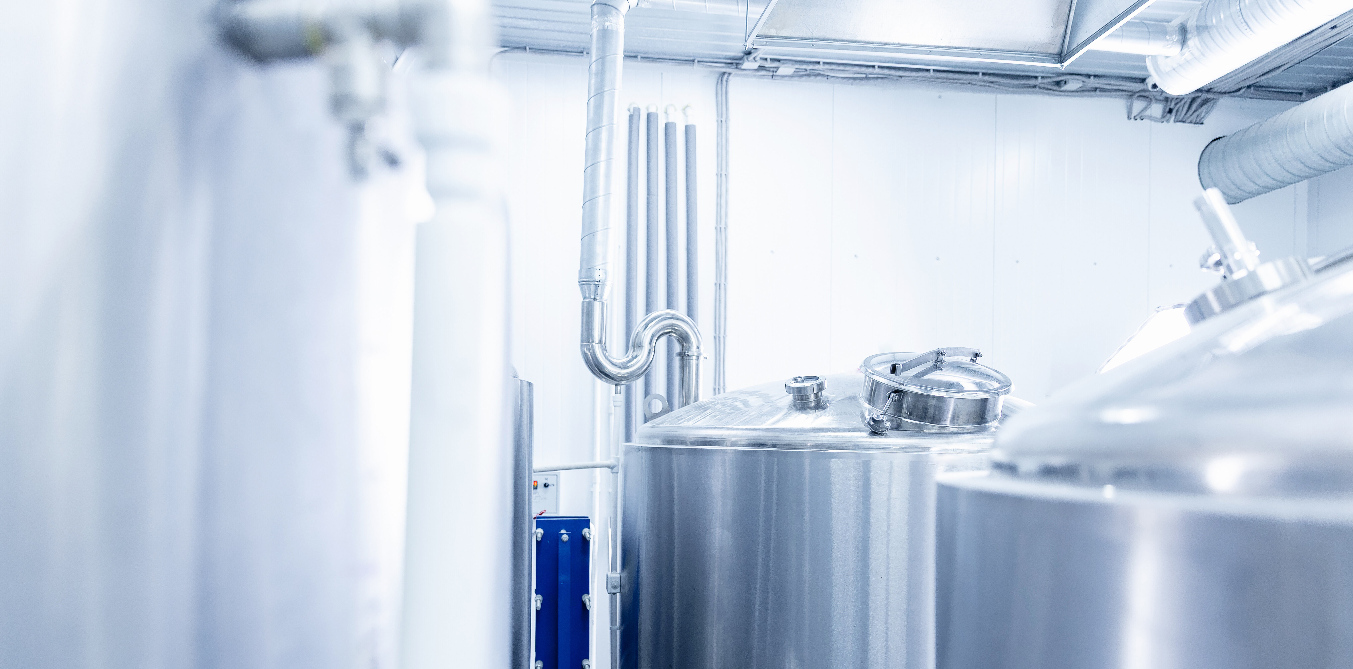 Industrial process equipment with stainless steel tanks and piping in a modern production environment