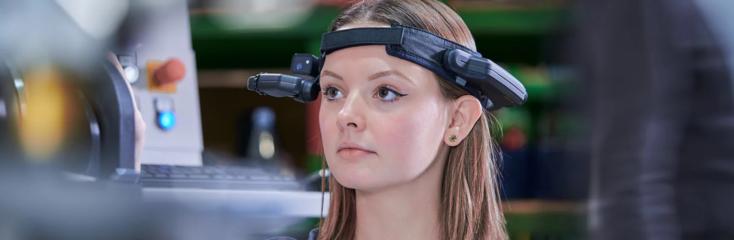  A skilled worker wearing a digital virtual reality headset stands in front of a laser machine.