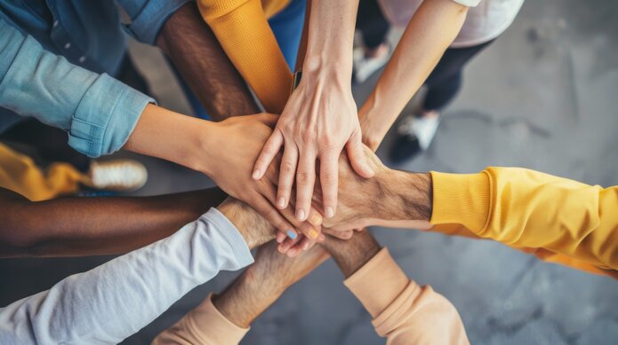  Hands of different people stacked on top of each other