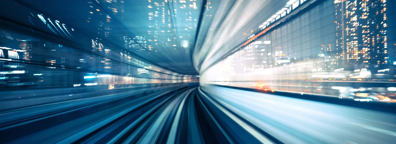 Schnappschuss einer Bewegtbildaufnahme aus dem inneren eines schnell fahrenden Fahrzeugs, im Hintergrund ist eine urbane Skyline