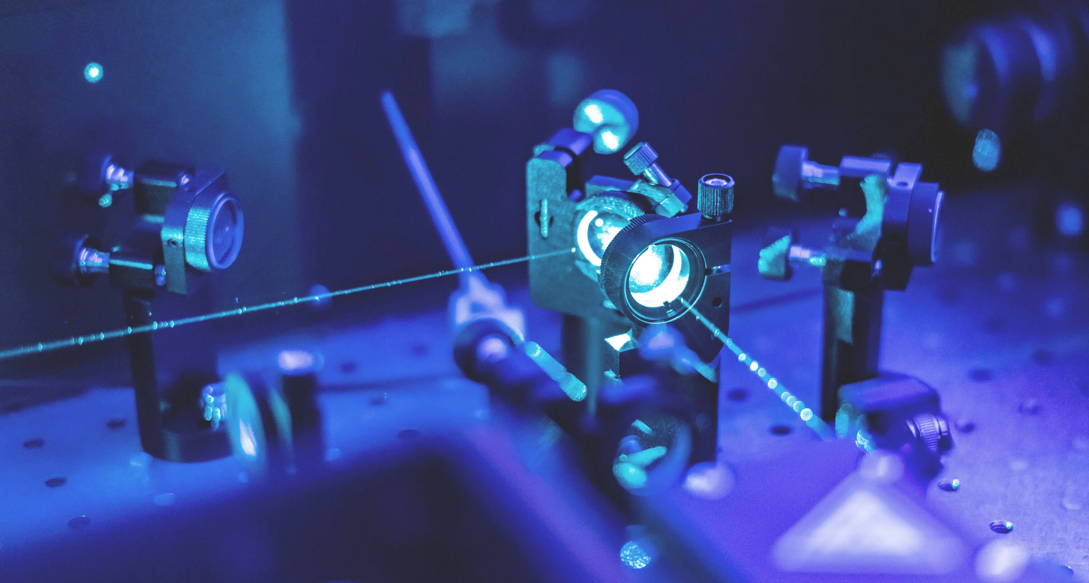  The inside of a laser apparatus, several mirrors and a laser beam shining through the mirrors inside the machine.