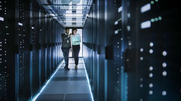  A man and a woman walk through a server room
