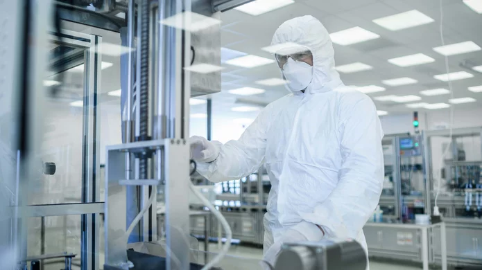  person in protective clothing with mask standing in a laboratory