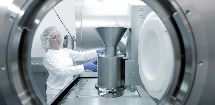 Laborantin bei der Arbeit mit einem pharmazeutischen Containment- und Klimaprüfsystem im Bereich Pharmatechnik.