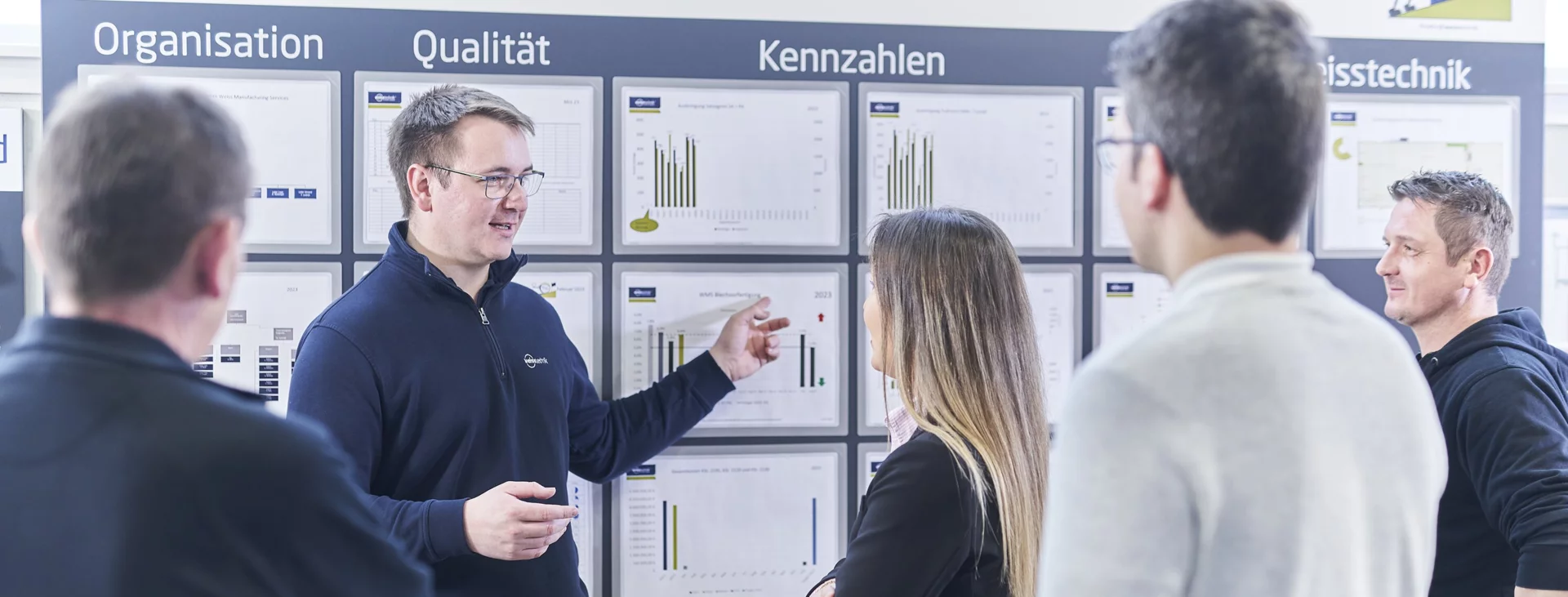 Schunk Group employees at a meeting on key figures in front of a whiteboard with various graphics and information