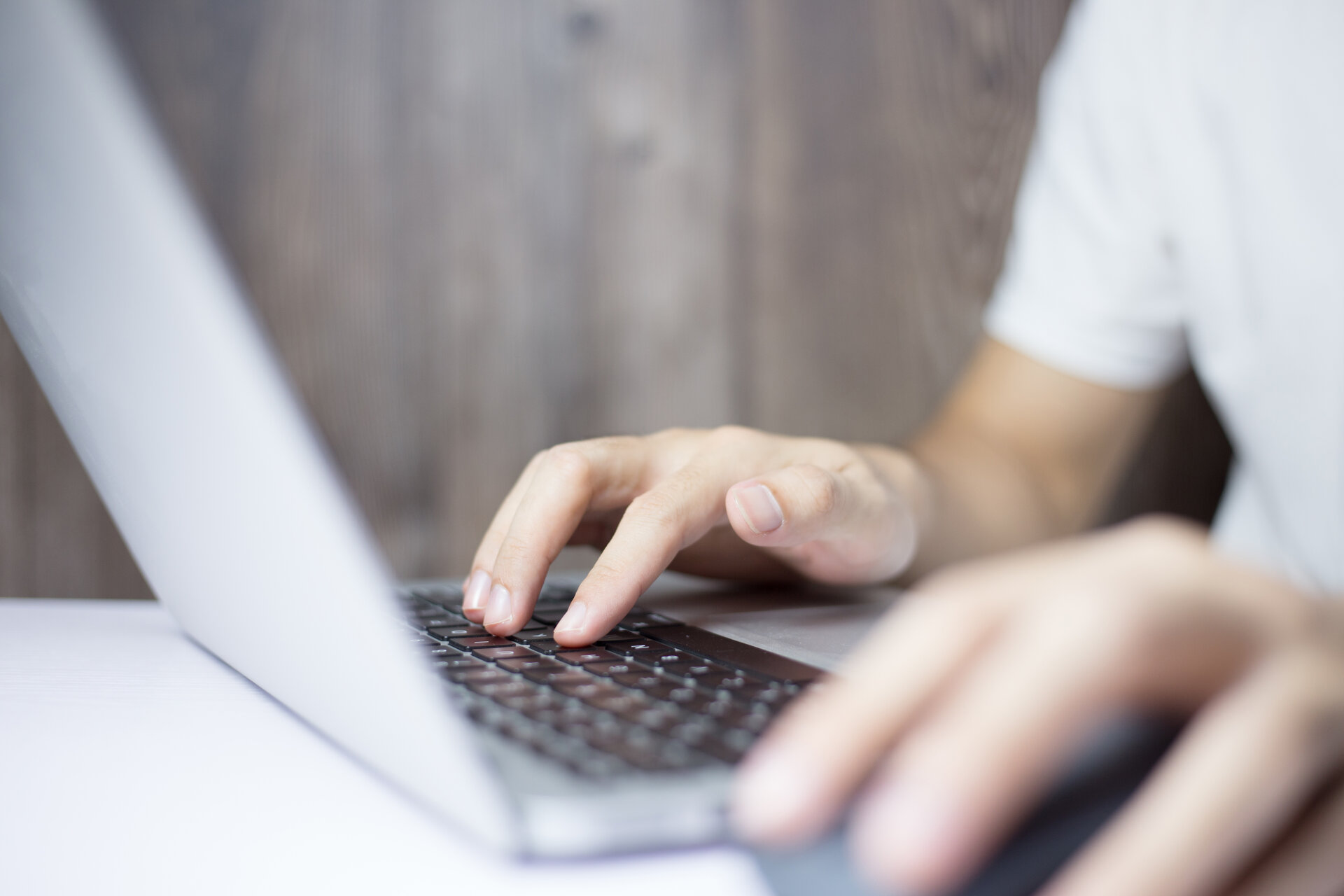  Person sits in front of a laptop while working and surfing the internet